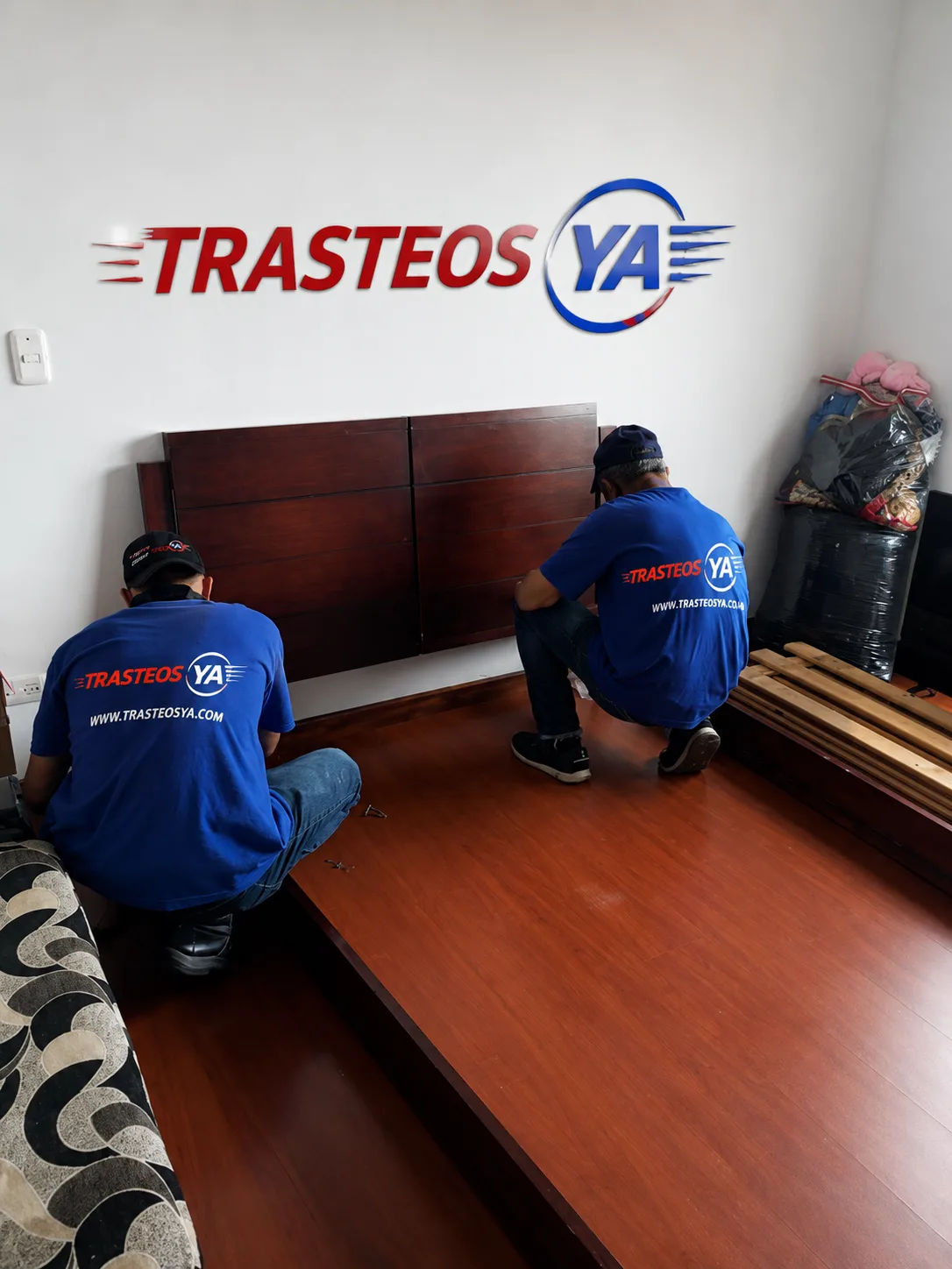 Operarios armando cama en habitación
